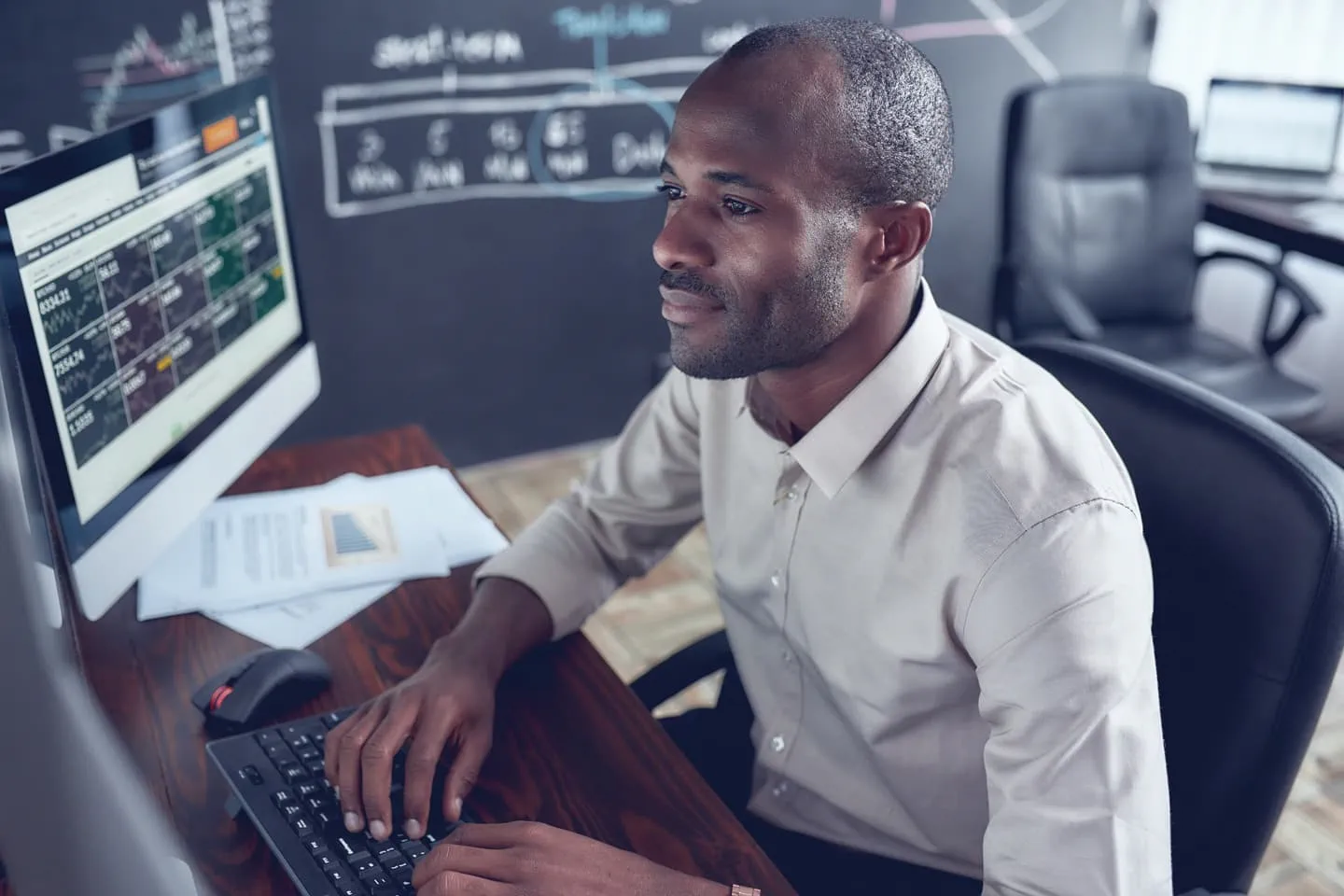Man looking at financial data on monitor
